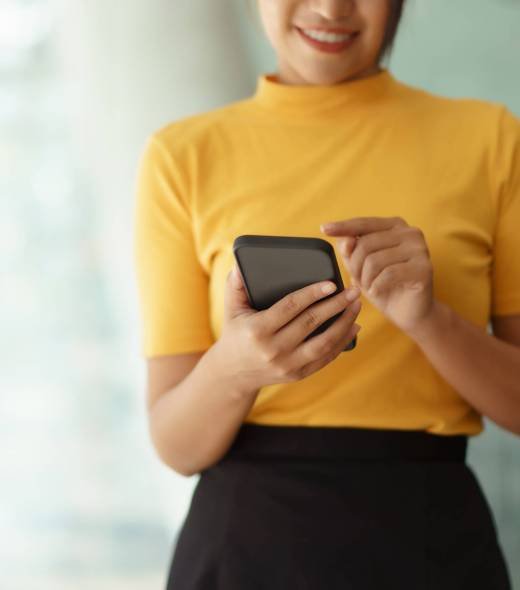 Closeup image of female using smartphone to send text , work or play social media.